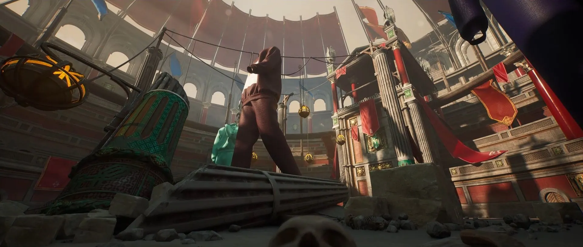 Inside the arena: stalls, ropes and figures under red banners, in cinemascope