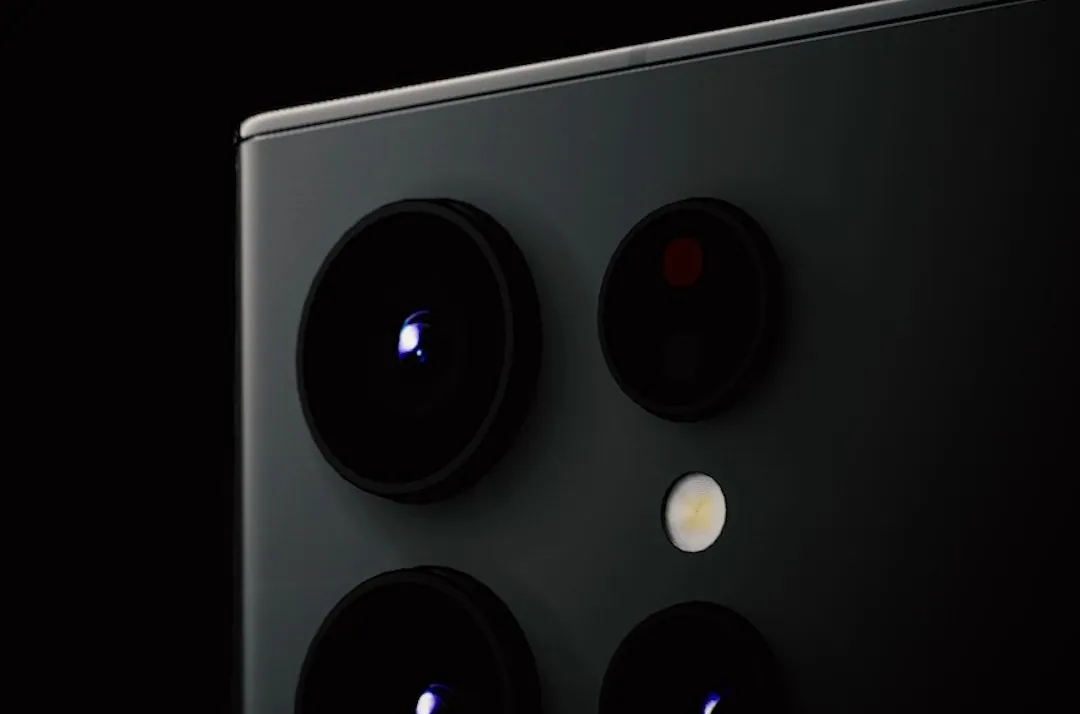 A close-up of a phone’s camera lenses in low, raking light