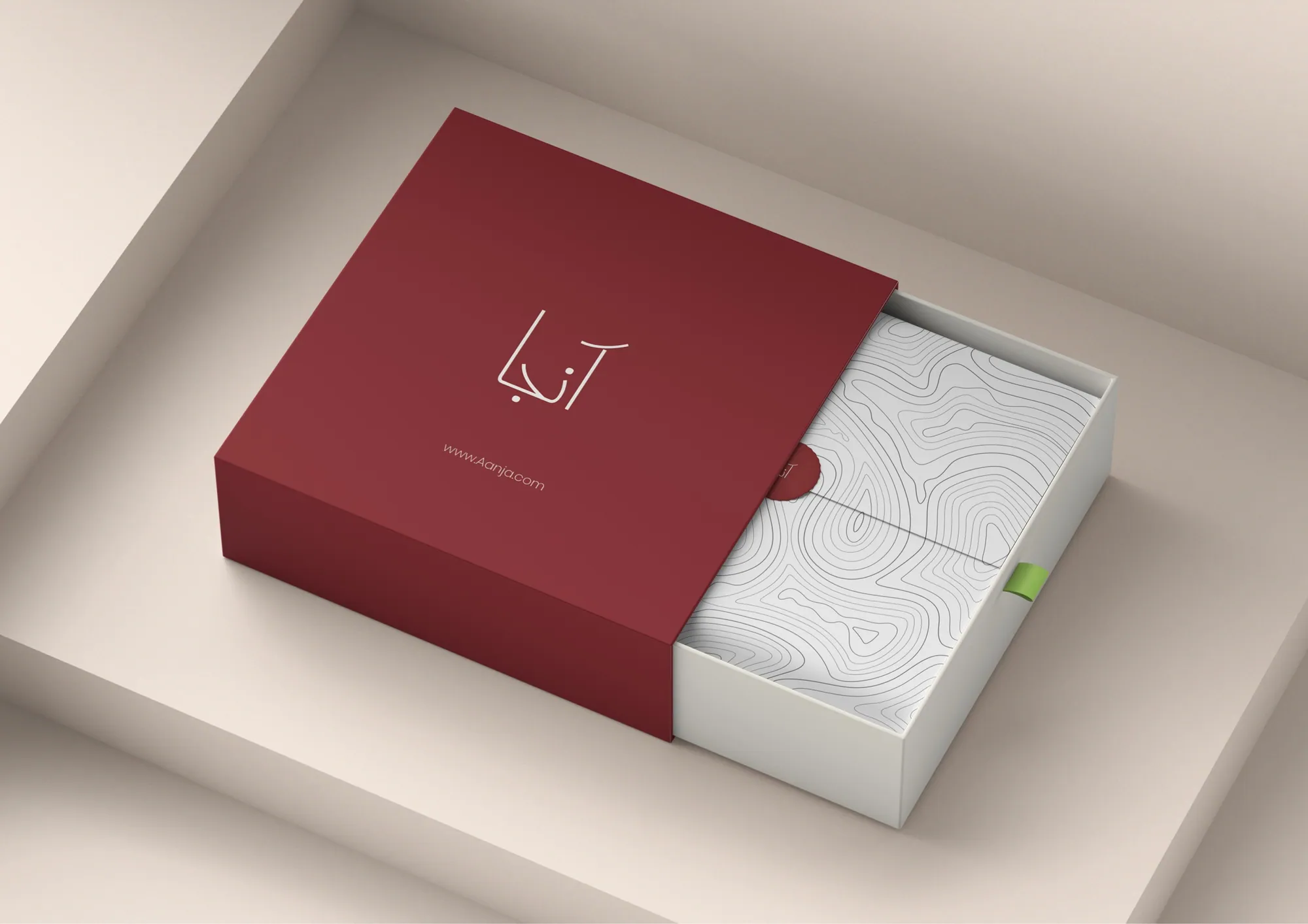 A deep red Aanja box sliding open on a white patterned inner box