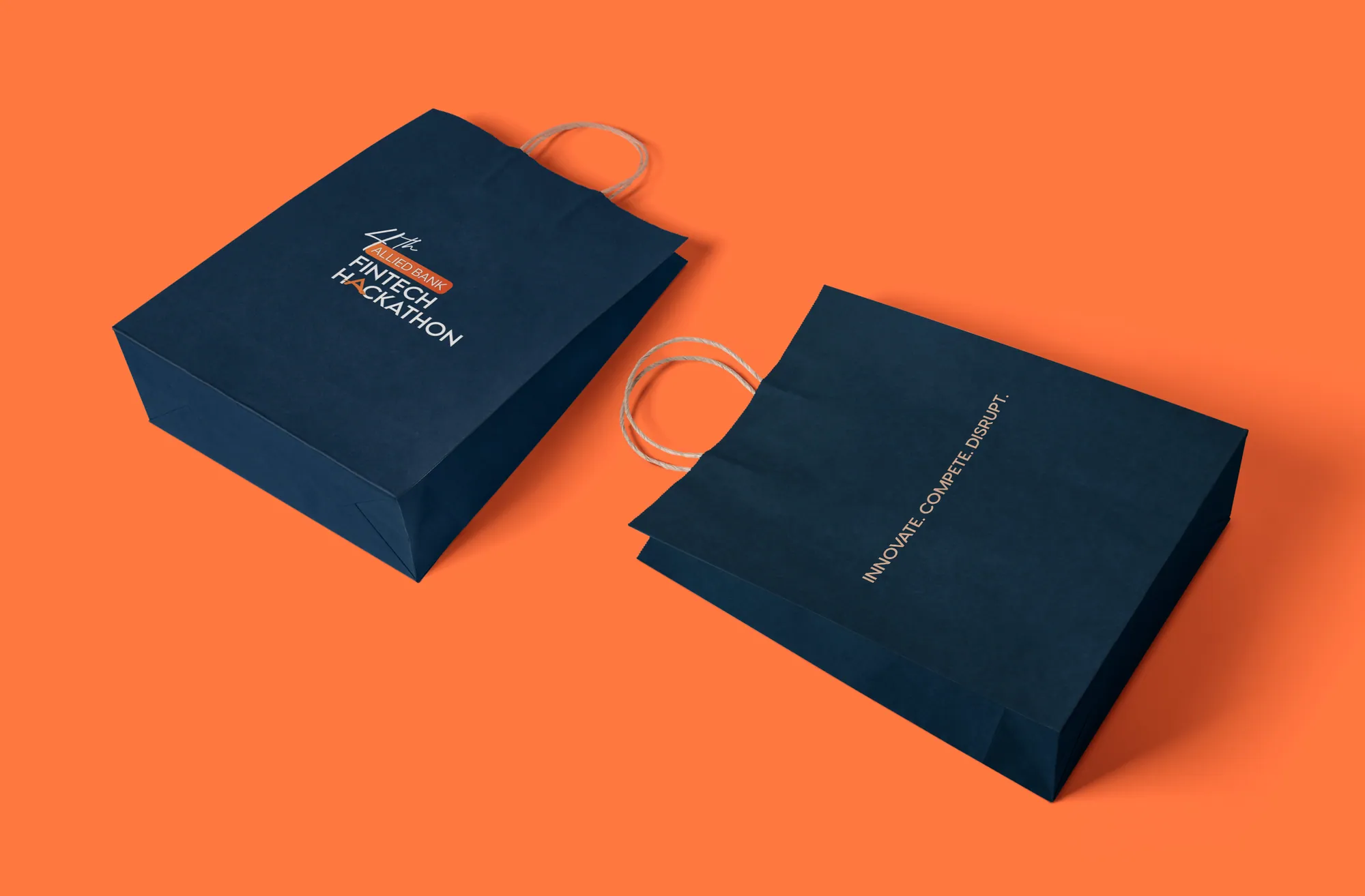 Navy paper shopping bags with the hackathon mark on orange
