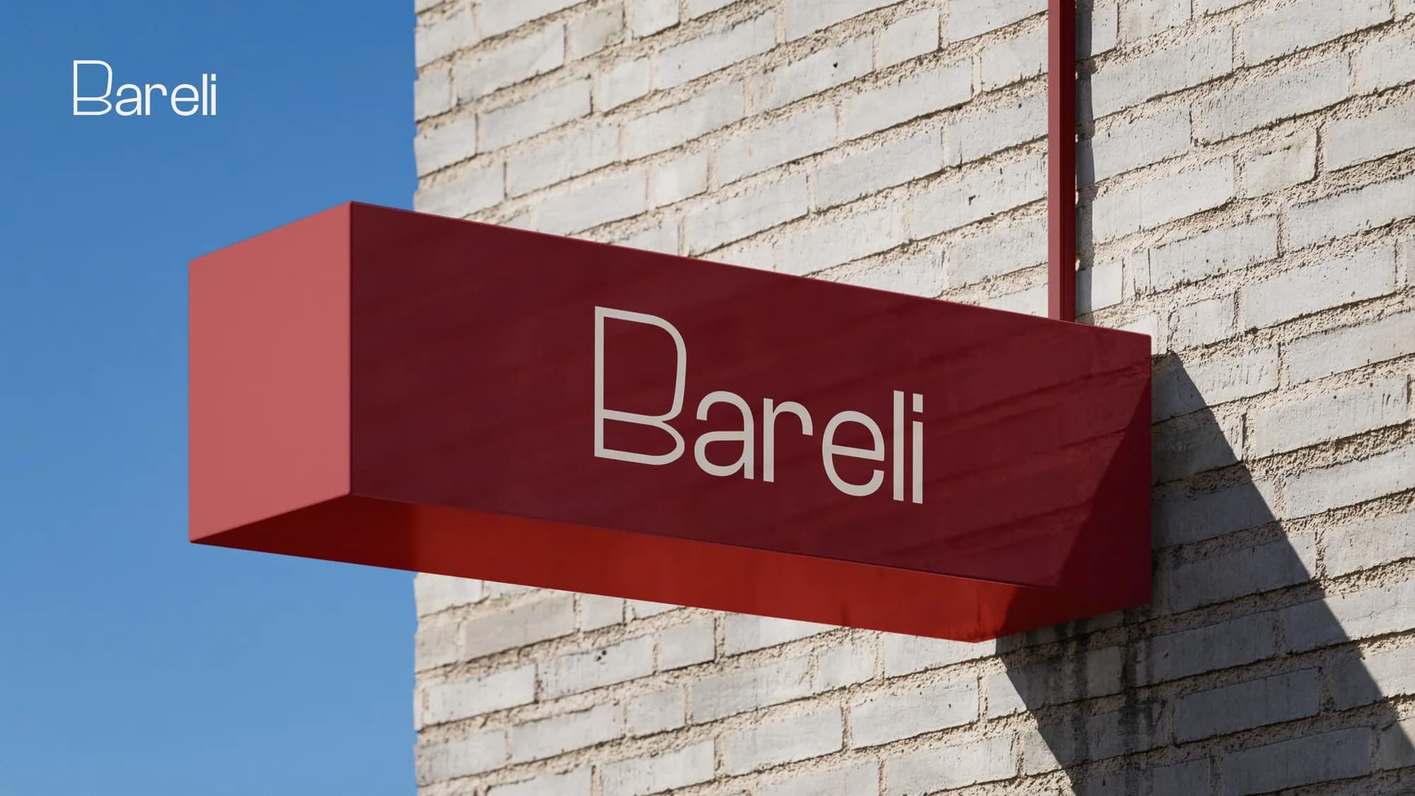 A red Bareli projecting sign on a brick wall against a blue sky