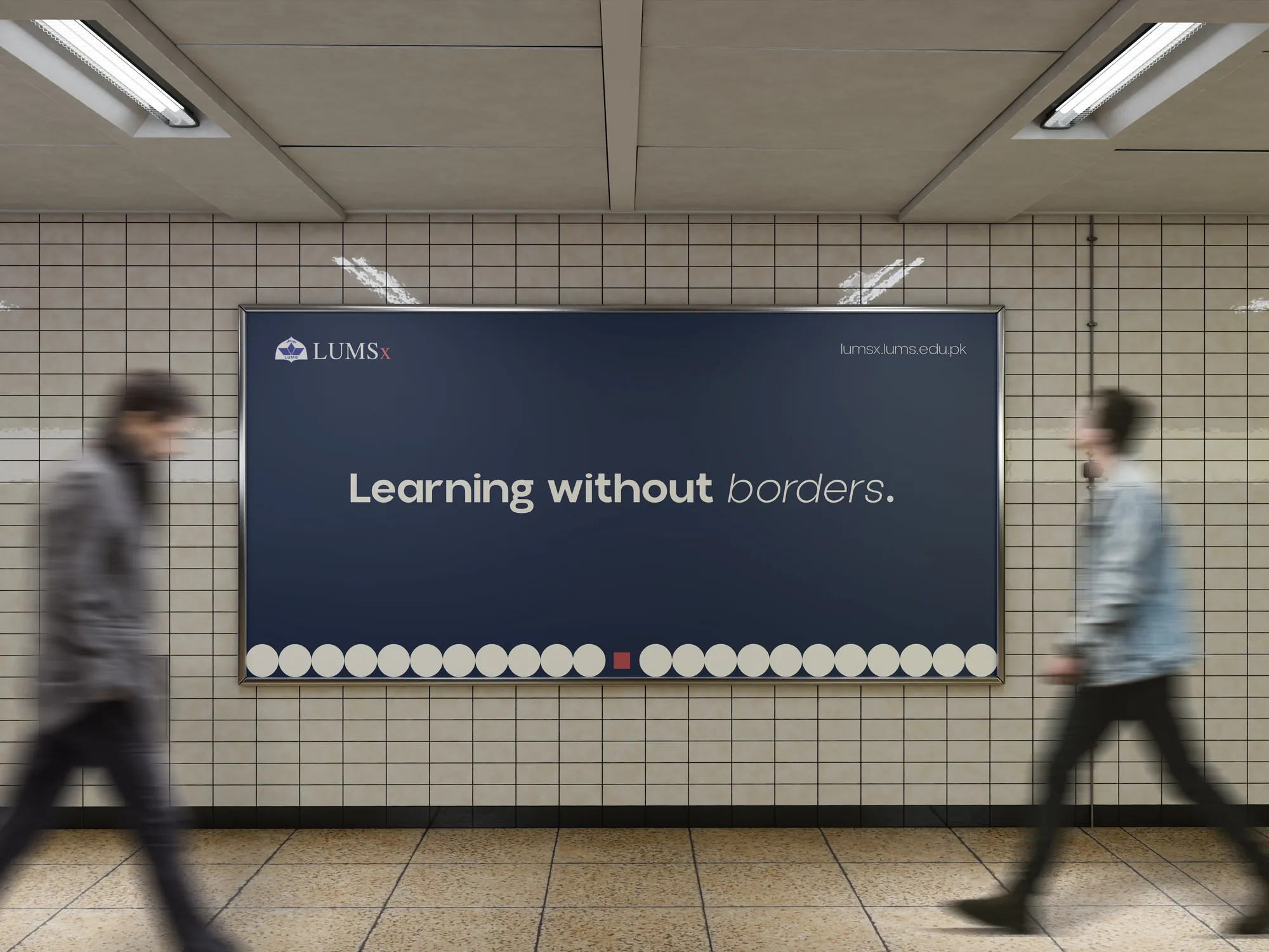A LUMSx billboard in an underground station, reading “Learning without borders.” in white on ink navy, with commuters walking past