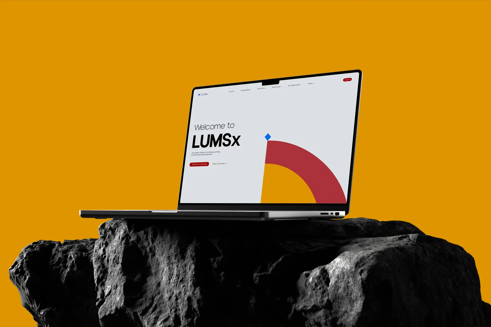The LUMSx website concept on a laptop on a dark rock, against marigold