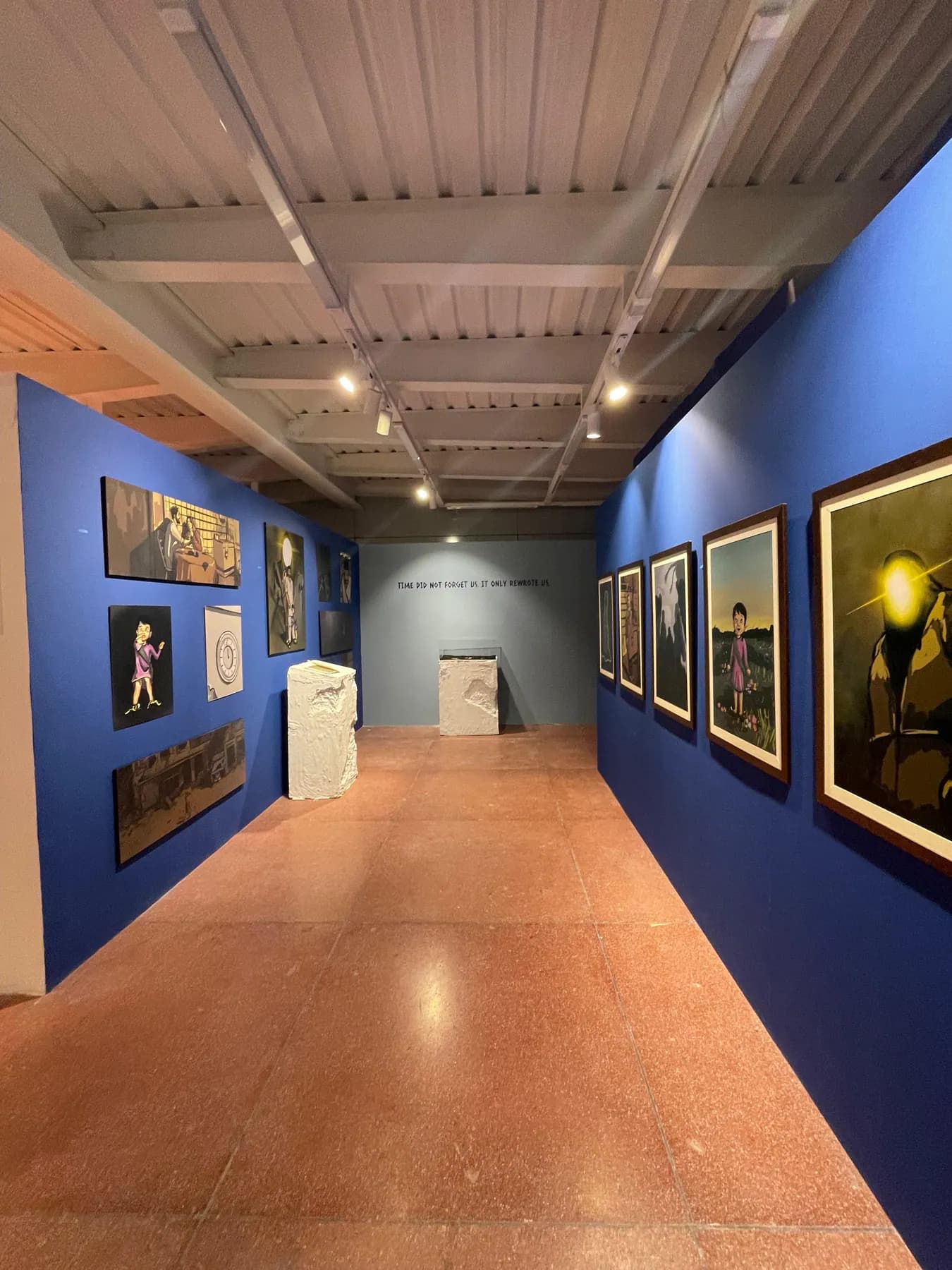 A corridor of the show lined with framed Talaash artworks on blue walls