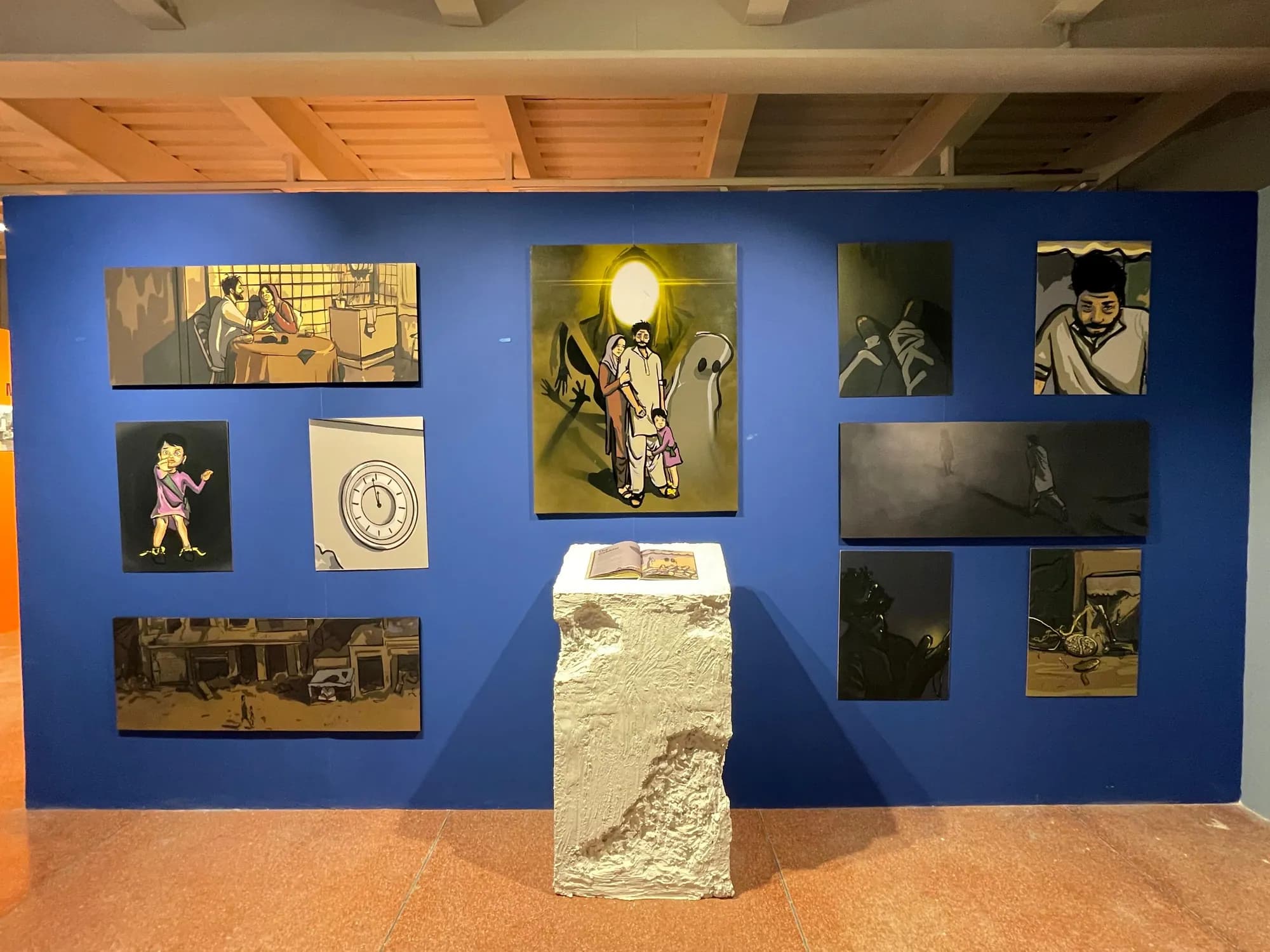The installation: a blue wall of artworks with the plinth in front